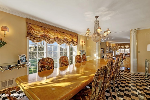 dining room with ornate columns, crown molding, and a chandelier