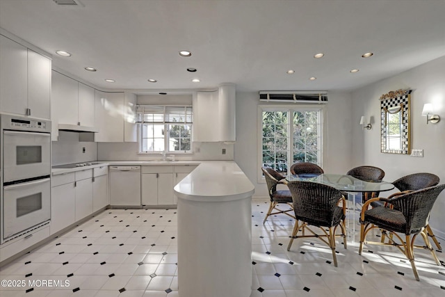 kitchen featuring white cabinetry, white appliances, and kitchen peninsula