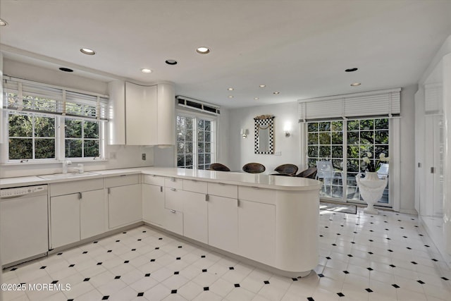 kitchen featuring white cabinetry, dishwasher, sink, and kitchen peninsula