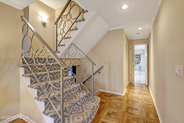 stairway with crown molding and parquet flooring