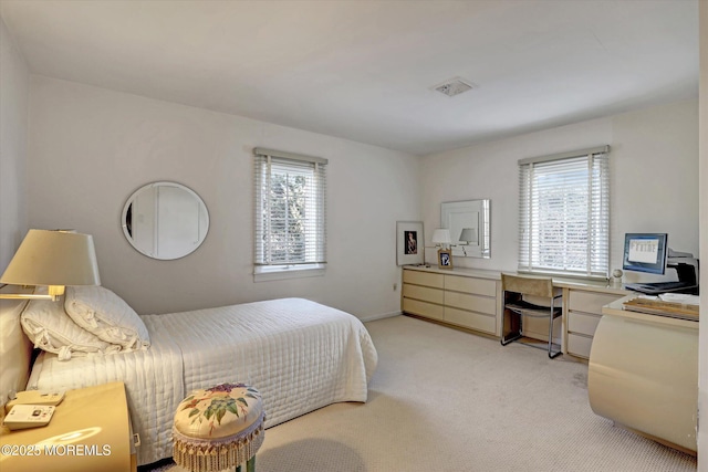 bedroom with multiple windows and light colored carpet