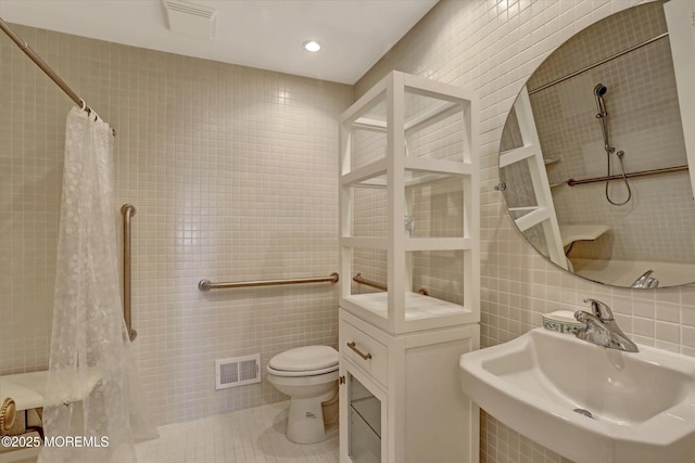 bathroom featuring sink, tile walls, walk in shower, toilet, and tile patterned floors