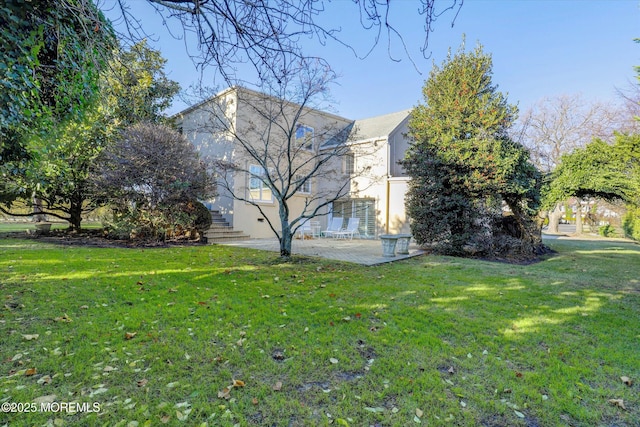 view of side of property with a yard and a patio area