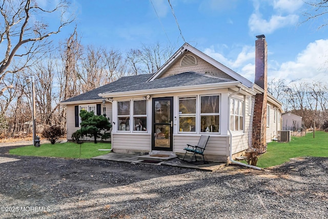 view of front of house with a front lawn, central AC unit, and a sunroom