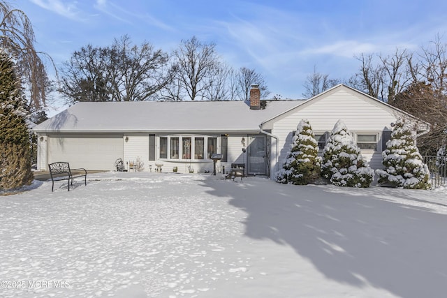 snow covered property with a garage