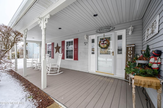 snow covered deck featuring a porch