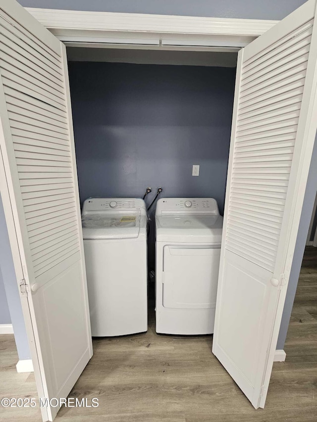 laundry area featuring independent washer and dryer and light hardwood / wood-style floors