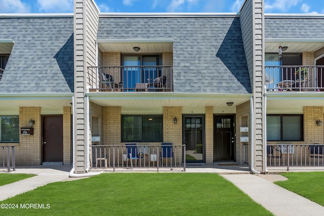 exterior space featuring covered porch and a front lawn