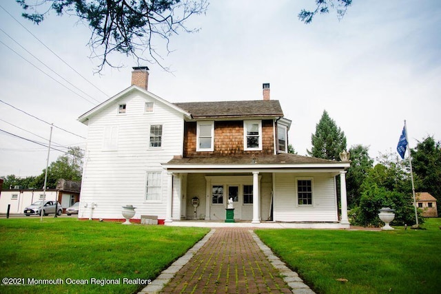 583 Cedar Ave, West Long Branch, NJ 07764 - view of front facade featuring a chimney, a porch, and a front lawn