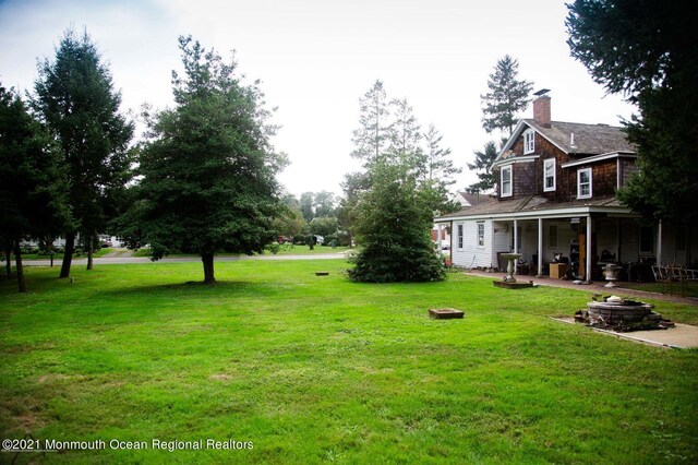 583 Cedar Ave, West Long Branch, NJ 07764 - view of grassy yard with a fire pit and a patio