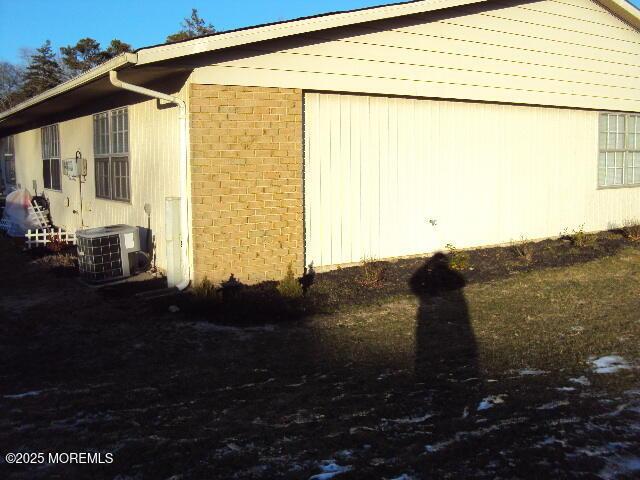 view of side of home with central air condition unit