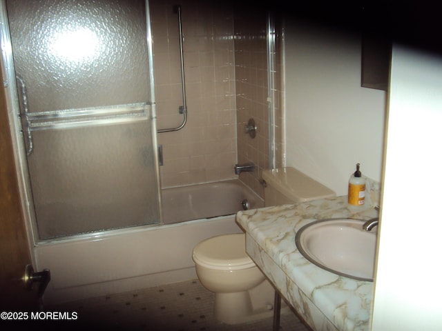 full bathroom with sink, tiled shower / bath combo, and toilet