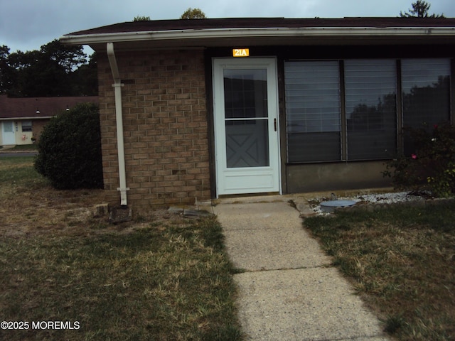 doorway to property featuring a lawn