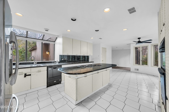 kitchen featuring dishwasher, stainless steel fridge, white cabinetry, and a kitchen island