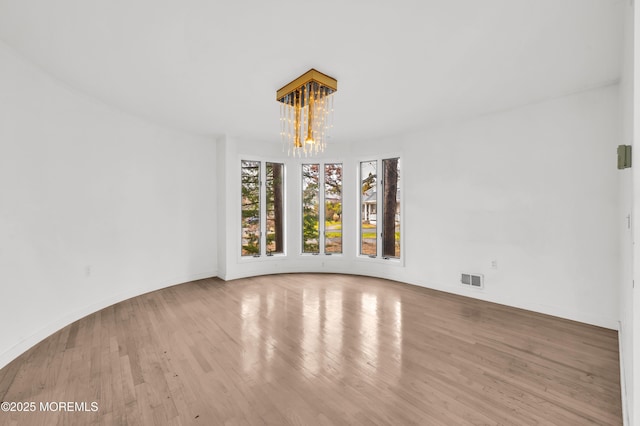 unfurnished dining area with light hardwood / wood-style flooring and a notable chandelier