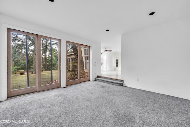 unfurnished living room with carpet and ceiling fan