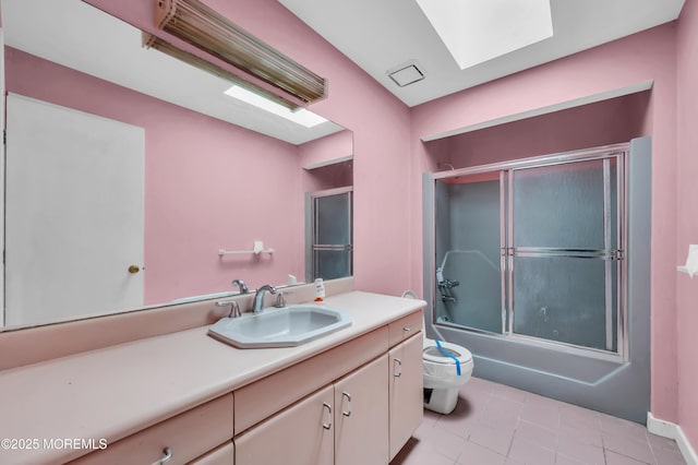 full bathroom featuring vanity, combined bath / shower with glass door, a skylight, tile patterned flooring, and toilet