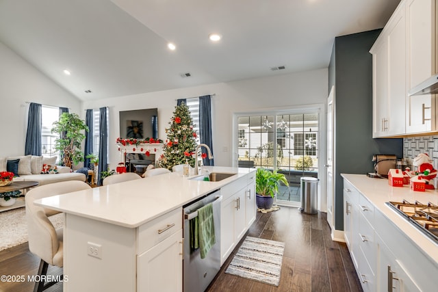 kitchen featuring white cabinetry, sink, an island with sink, a kitchen bar, and appliances with stainless steel finishes