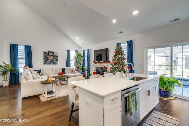 kitchen featuring sink, stainless steel dishwasher, dark hardwood / wood-style floors, an island with sink, and white cabinets