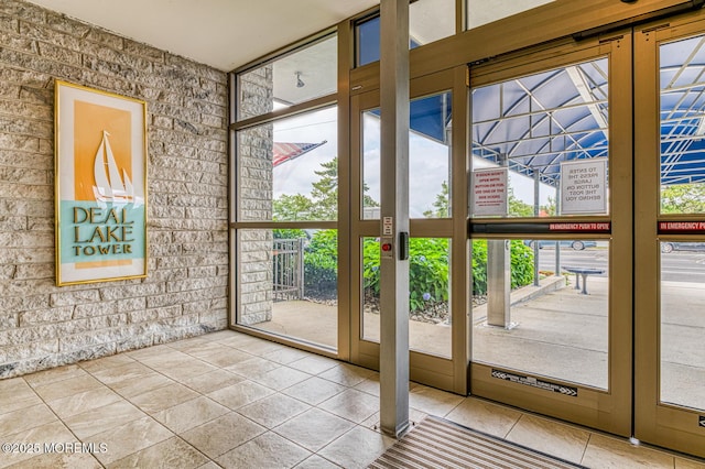 doorway to outside featuring floor to ceiling windows, tile patterned flooring, and a wealth of natural light