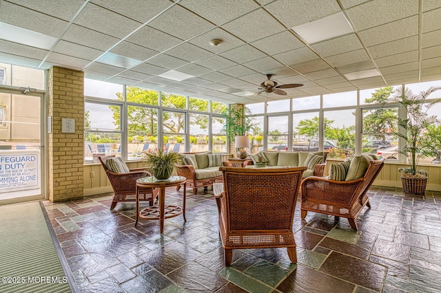 sunroom / solarium featuring ceiling fan and a drop ceiling