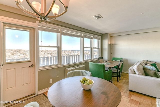 dining space featuring an inviting chandelier and light parquet floors