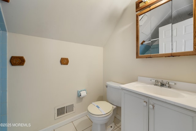 bathroom with toilet, lofted ceiling, tile patterned floors, and vanity