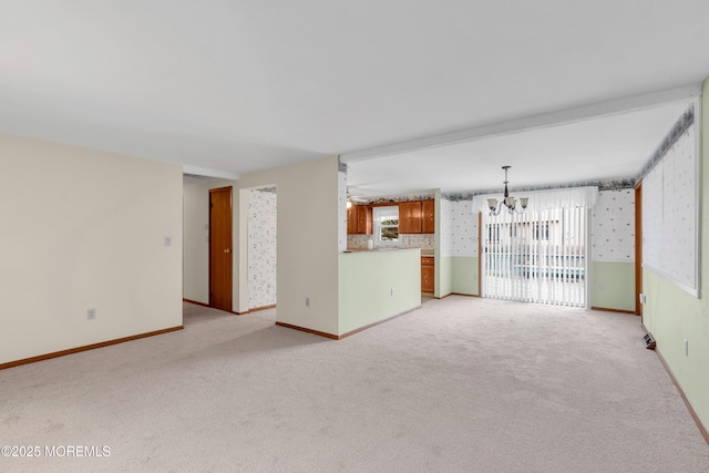 unfurnished living room featuring light carpet and ceiling fan with notable chandelier