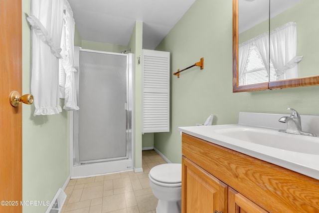 bathroom with tile patterned flooring, vanity, toilet, and a shower with door