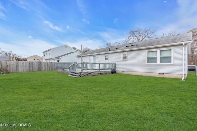 rear view of house featuring a yard and a wooden deck