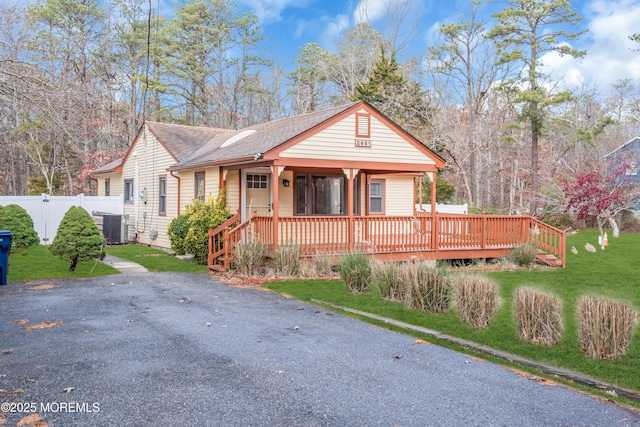 view of front of house featuring central AC, a front lawn, and covered porch