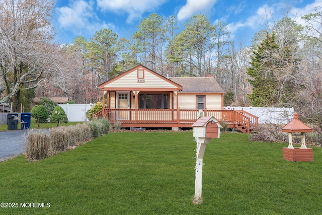 view of front of house featuring a front lawn and a wooden deck