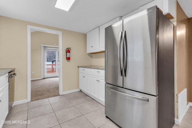 kitchen featuring white cabinetry, light colored carpet, stainless steel appliances, and light stone counters