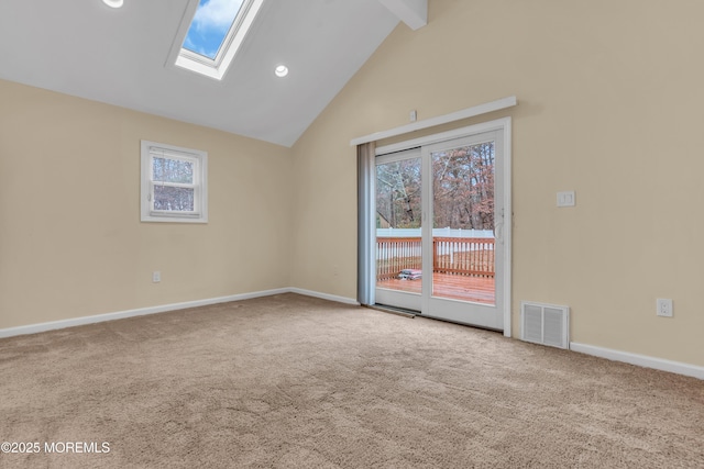 carpeted spare room with beam ceiling, a skylight, and high vaulted ceiling