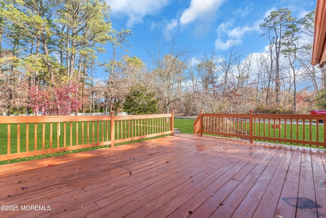 wooden deck featuring a lawn