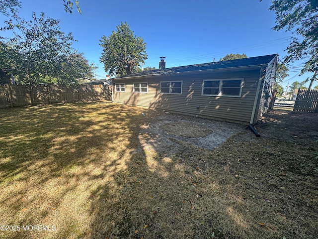 rear view of property featuring a yard