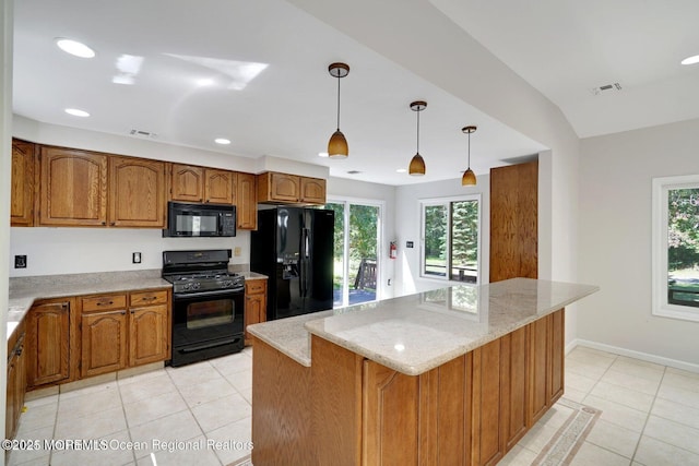 kitchen with hanging light fixtures, a center island, light tile patterned floors, and black appliances