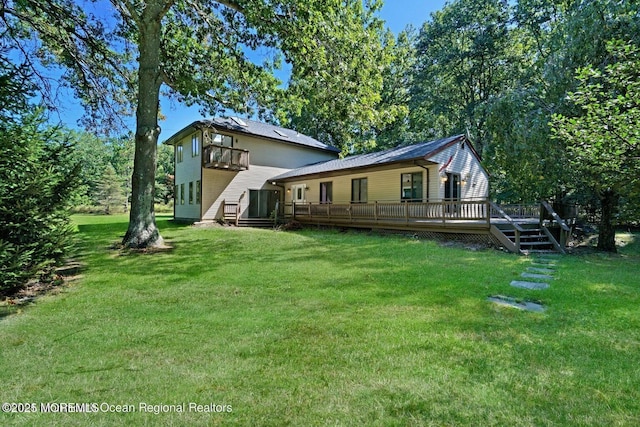 rear view of house with a deck and a lawn