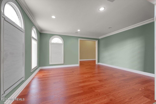 empty room featuring light hardwood / wood-style flooring and crown molding