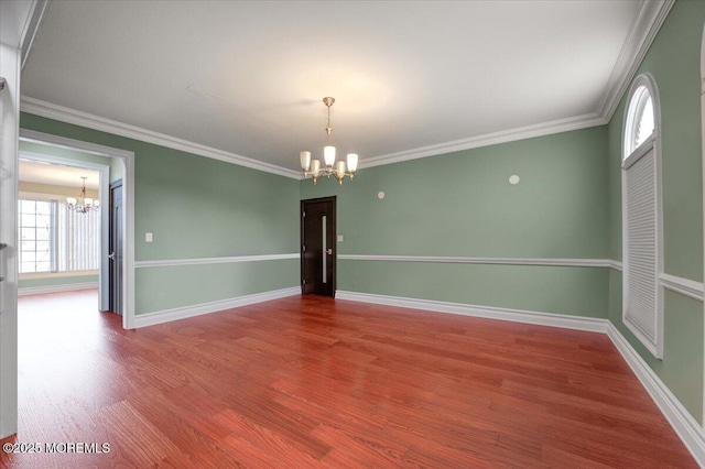 empty room with a chandelier, crown molding, and a healthy amount of sunlight