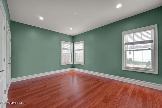 unfurnished room featuring hardwood / wood-style floors and plenty of natural light