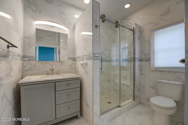 bathroom featuring vanity, toilet, tile walls, and a shower with shower door