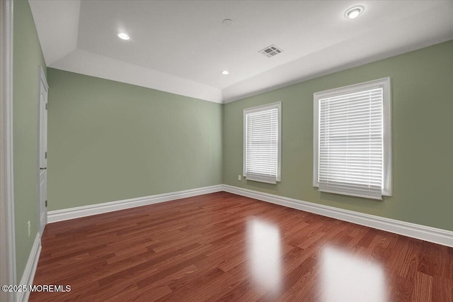 empty room featuring hardwood / wood-style flooring and lofted ceiling