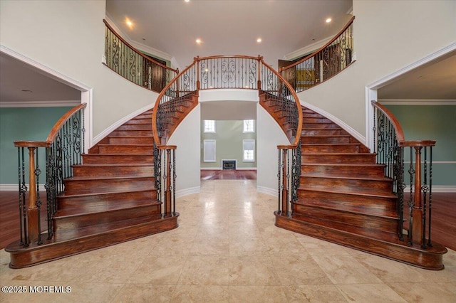 stairs with a high ceiling and crown molding