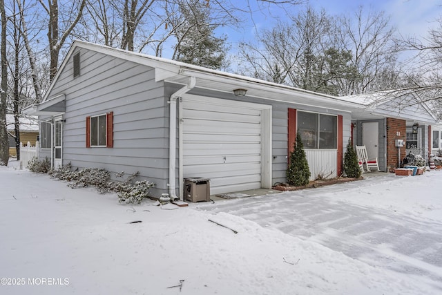 snow covered property with a garage