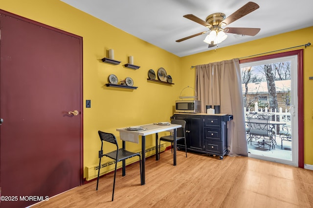 office area featuring baseboard heating, ceiling fan, and light hardwood / wood-style flooring