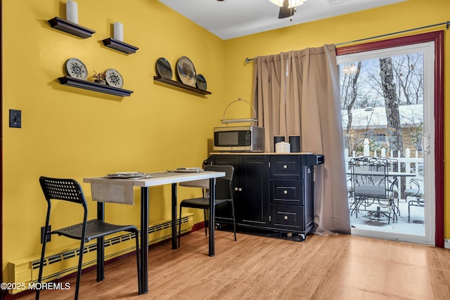 office space featuring ceiling fan, light wood-type flooring, and a baseboard radiator