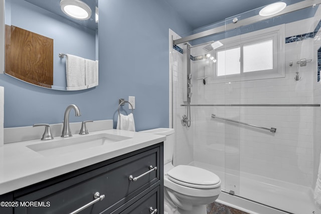 bathroom featuring vanity, toilet, and walk in shower