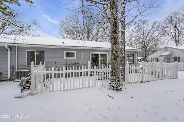 snow covered back of property with central air condition unit