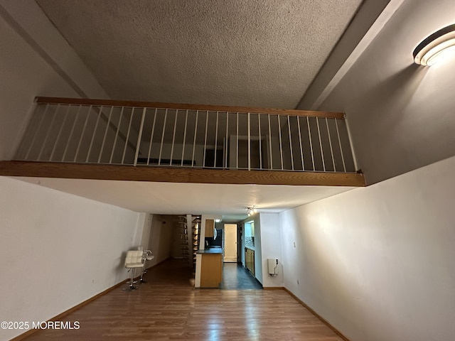 stairs featuring hardwood / wood-style flooring, a towering ceiling, and a textured ceiling